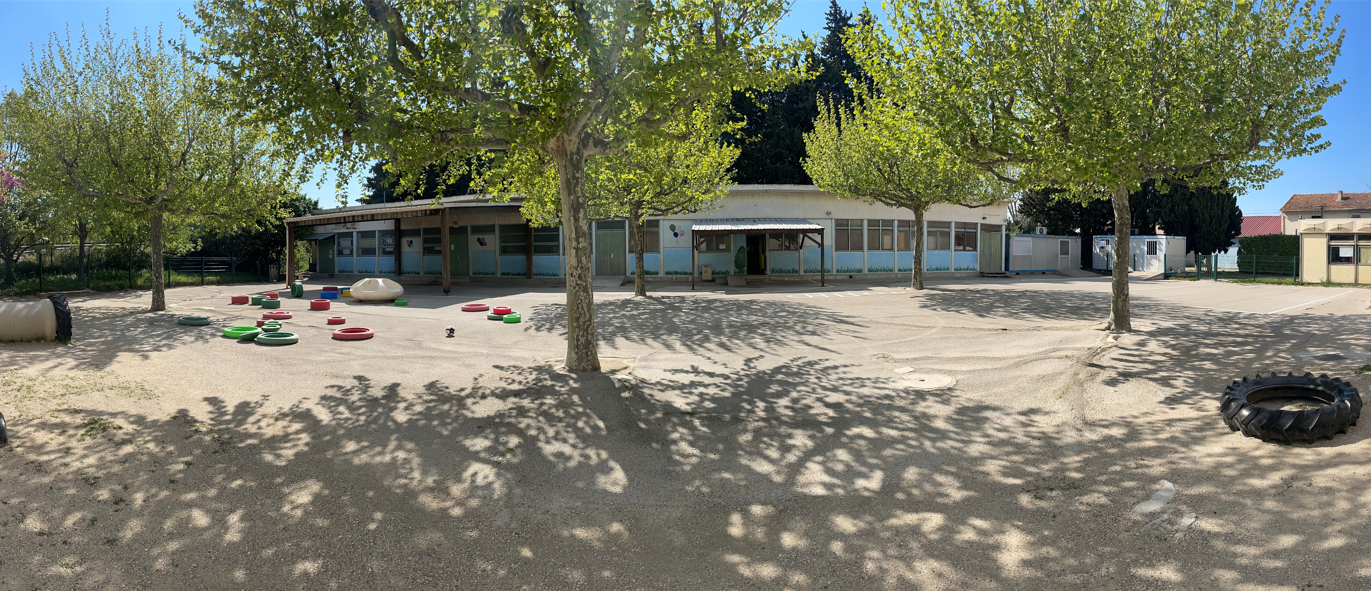 La cour de l'école. Le bâtiment abrite les classes, le secrétariat, le réfectoire, la bibliothèque et la salle informatique.